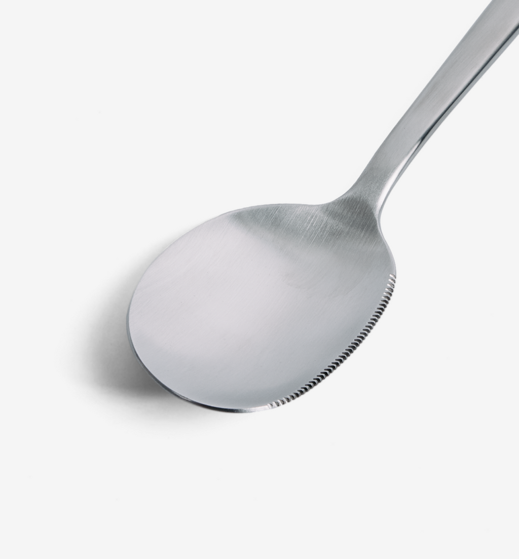 Stainless steel spoon with serrated edge detail